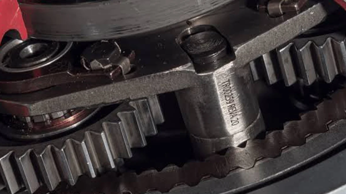 Laser-marked metal component with alphanumeric identification in a precision mechanical assembly