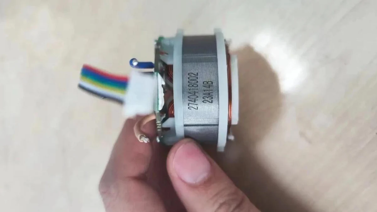 Laser-marked electric motor component with an alphanumeric identification code