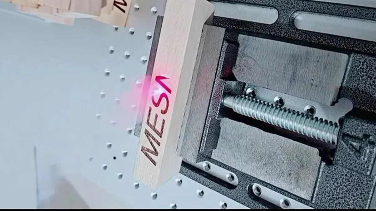 Laser marking text on a solid wood workpiece held on a machine fixture