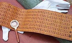 Character-marked slatted material shown with a glove and magnifier