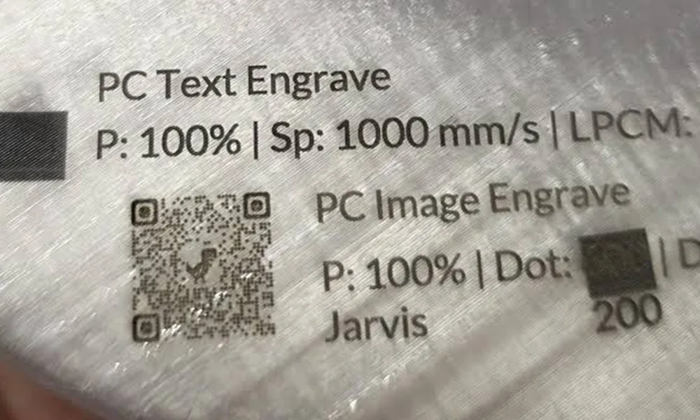 Polycarbonate laser marking sample with text, contrast blocks and a QR code