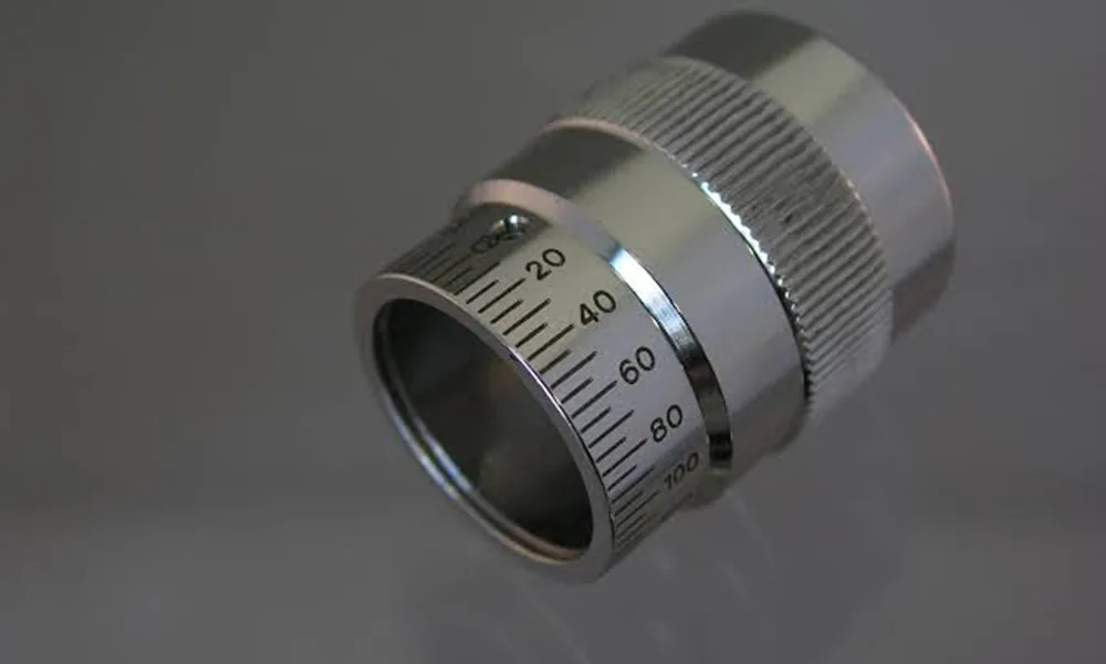 Laser-marked scale on a cylindrical metal component